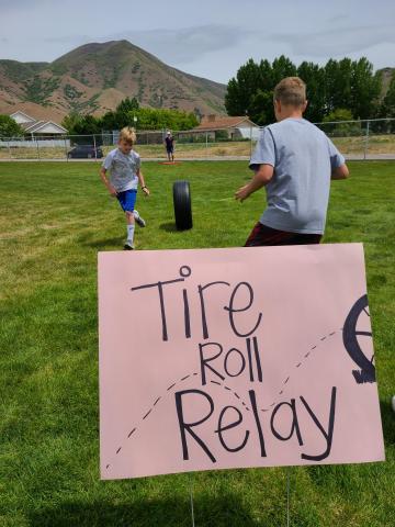 students by "Tire Roll relay" sign
