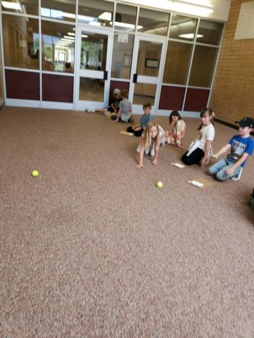 Students testing out energy with a tennis ball.